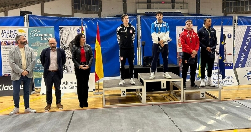 4 osoby stoją na podium. 3 osoby po lewej stoją obok podium. 