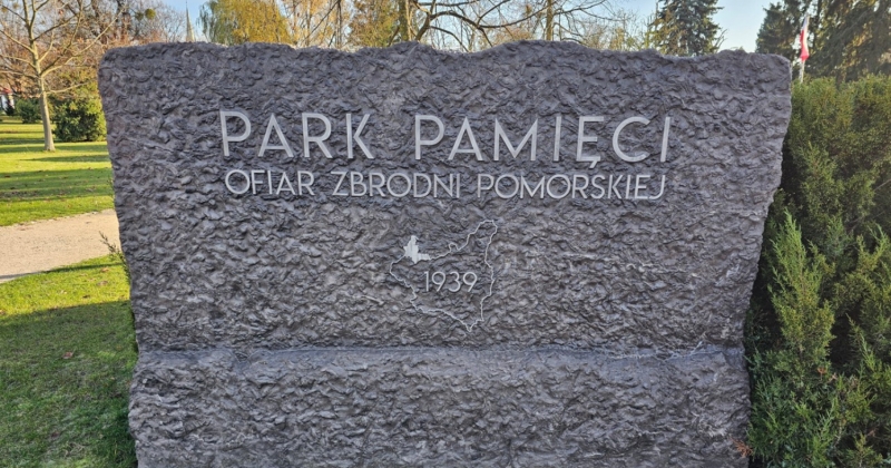 Kamienna tablica z napisem "PARK PAMIĘCI OFIAR ZBRODNI POMORSKIEJ" i konturem gracic II RP z wpisaną w niego data 1939